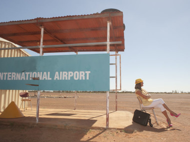 woman waiting on sand outside international airport