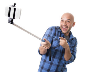 man taking selfie on selfie stick