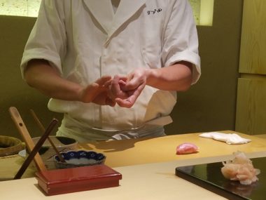 person making sushi