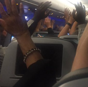 people in cabin with hands up