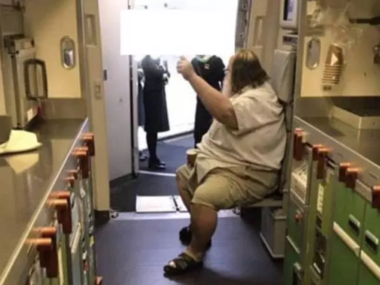 man raising hand on plane