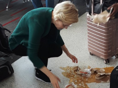 women cleaning up spilled drink on airport floor