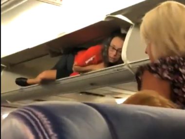flight attendant in overhead bin