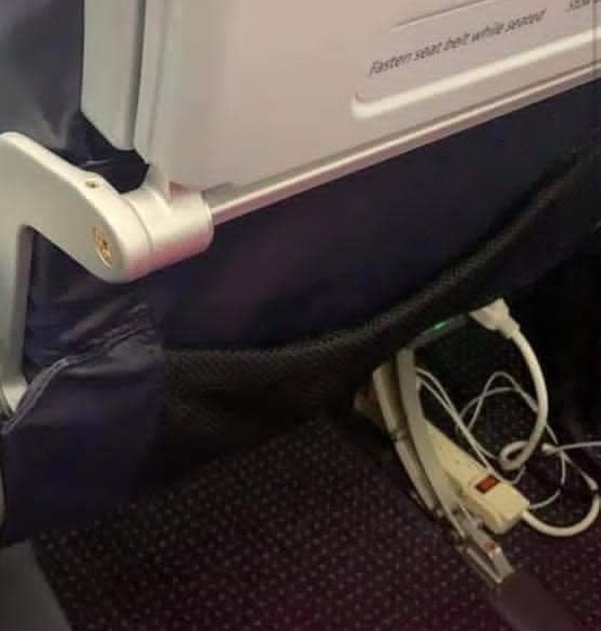Passenger Plugs In Power Strip At Their Seat To Charge Multiple Devices