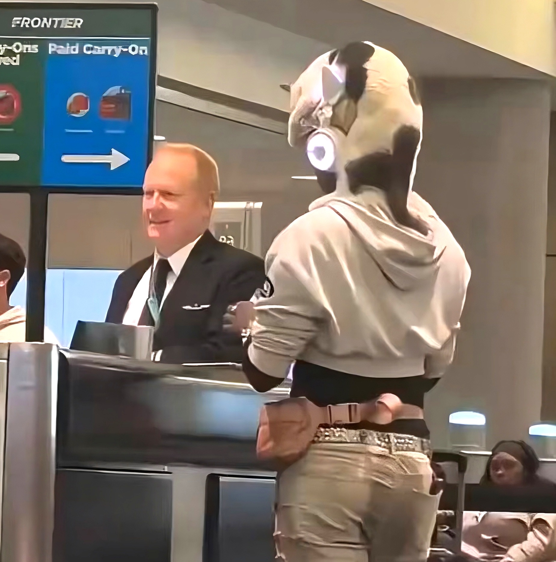 Frontier Airlines Passenger Wore A Cat Like A Hat At The Gate — Then Adjusted It Over His Headphones